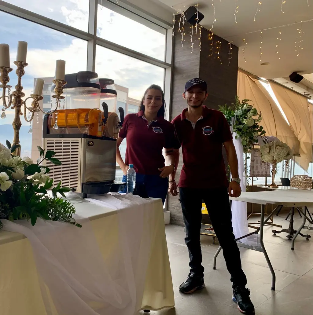 Bartender profesional en uniforme preparando cóctel con técnica precisa